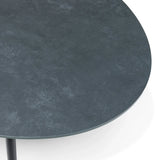 Close-up of round stone effect coffee table with dark textured tabletop