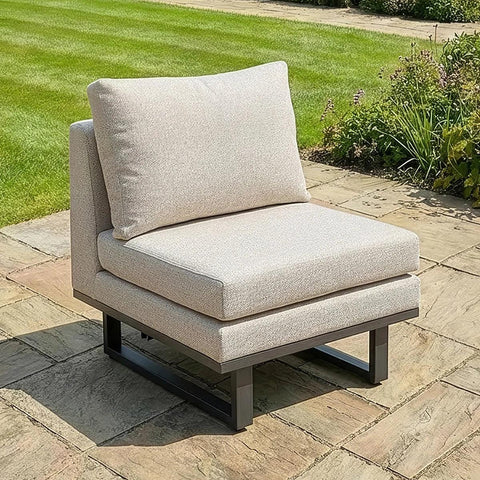Beige outdoor garden corner chair with thick cushions on stone patio