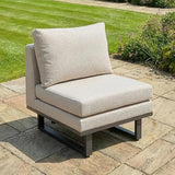 Beige outdoor garden corner chair with thick cushions on stone patio