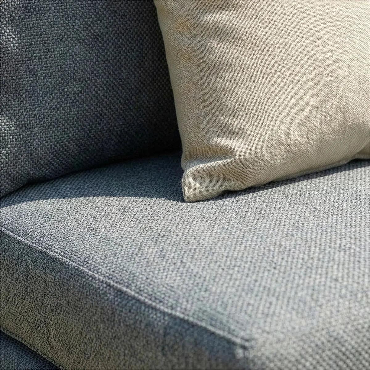 Grey fabric sofa seat with close view of beige cushion detail