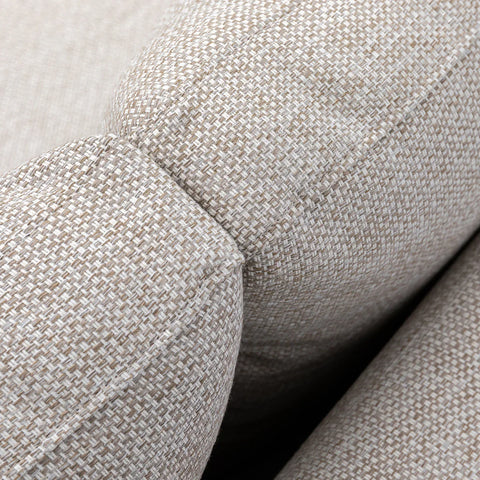 Closeup of beige fabric sofa armrest showing textured upholstery detail