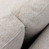 Closeup of beige fabric sofa armrest showing textured upholstery detail