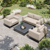 Beige outdoor sofa set with armchairs and slatted coffee table on stone patio