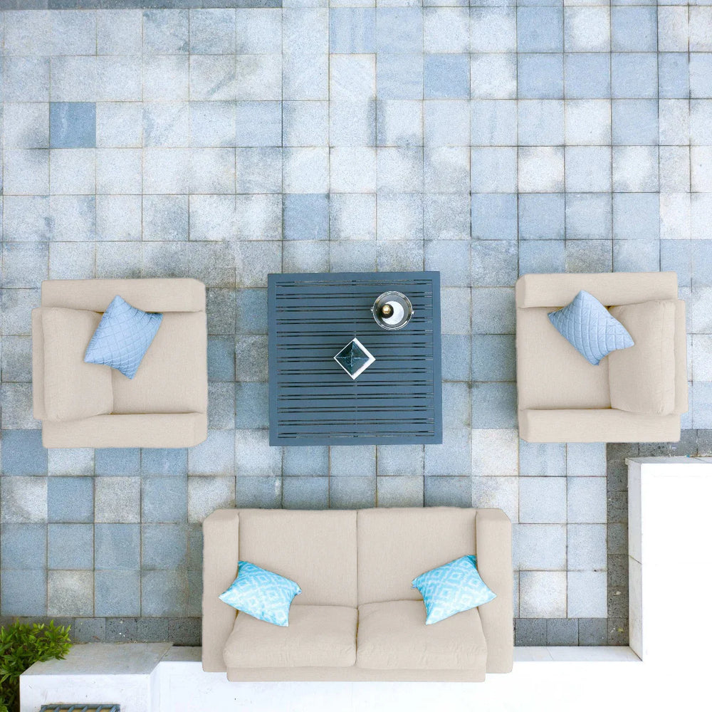 Outdoor patio furniture set with beige sofa, two armchairs and a grey coffee table, top view