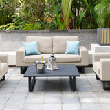 Beige outdoor sofa set with blue cushions and black coffee table on a tiled patio