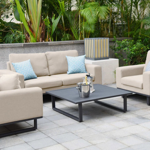 Beige outdoor sofa set with blue cushions and black coffee table on patio