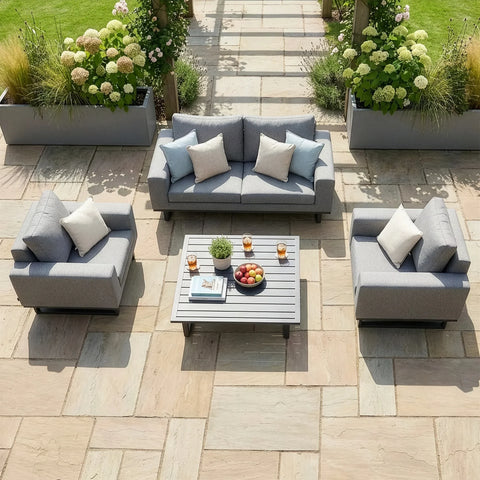 Grey outdoor garden sofa set with armchairs and coffee table on stone patio