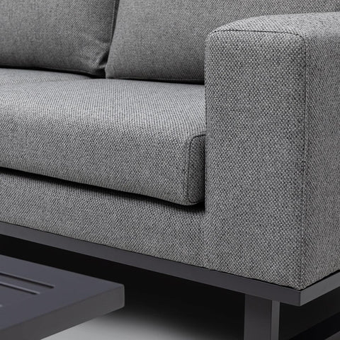 Close-up of grey fabric sofa armrest and cushion with black metal base