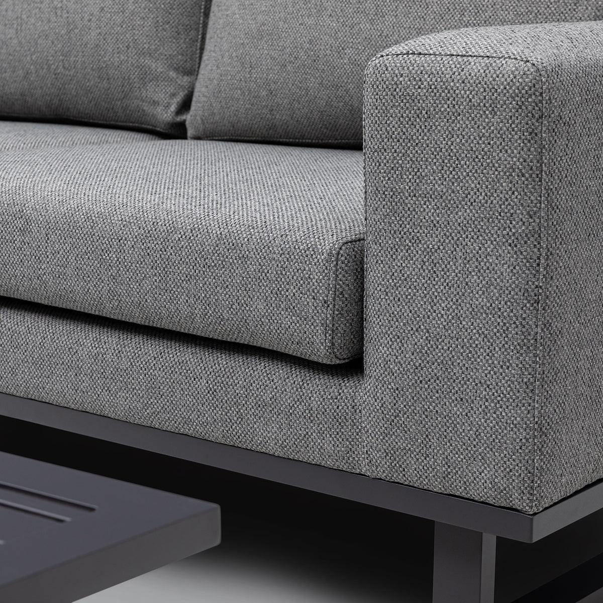 Close-up of grey fabric sofa armrest and cushion with black metal base