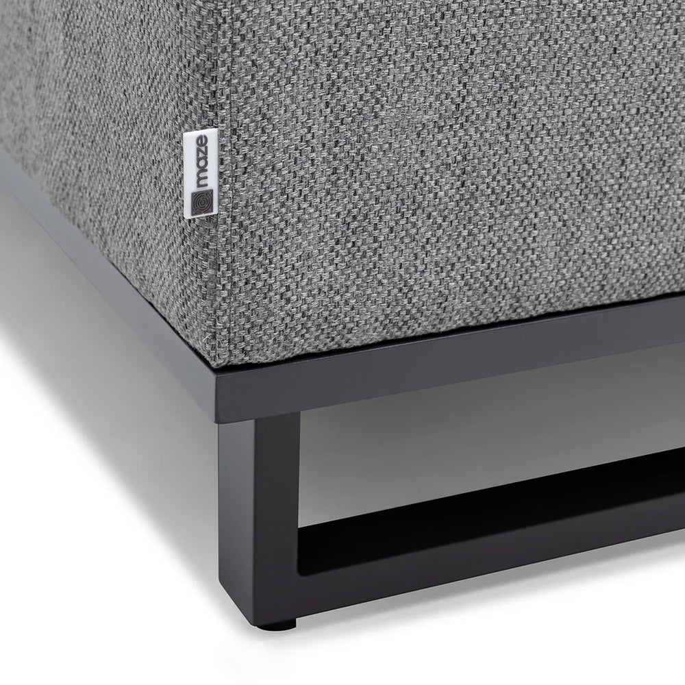 Grey fabric sofa corner with black metal base and textured upholstery detail