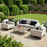 Beige garden sofa set with armchairs and grey cushions on patio, wooden coffee table in center