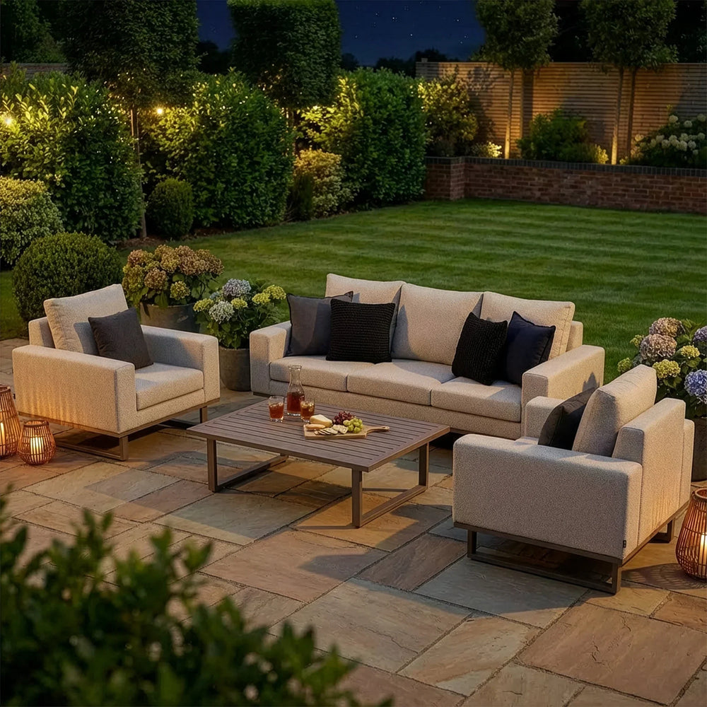 Modern outdoor garden sofa set with cream cushions and coffee table on a patio at dusk