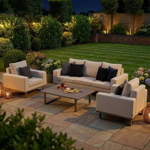 Modern outdoor garden sofa set with cream cushions and coffee table on a patio at dusk