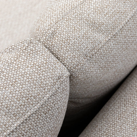 Close-up of beige fabric sofa armrest with textured upholstery and visible stitching