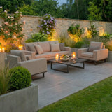 Outdoor patio sofa set with beige cushions, armchairs, and coffee table with candles