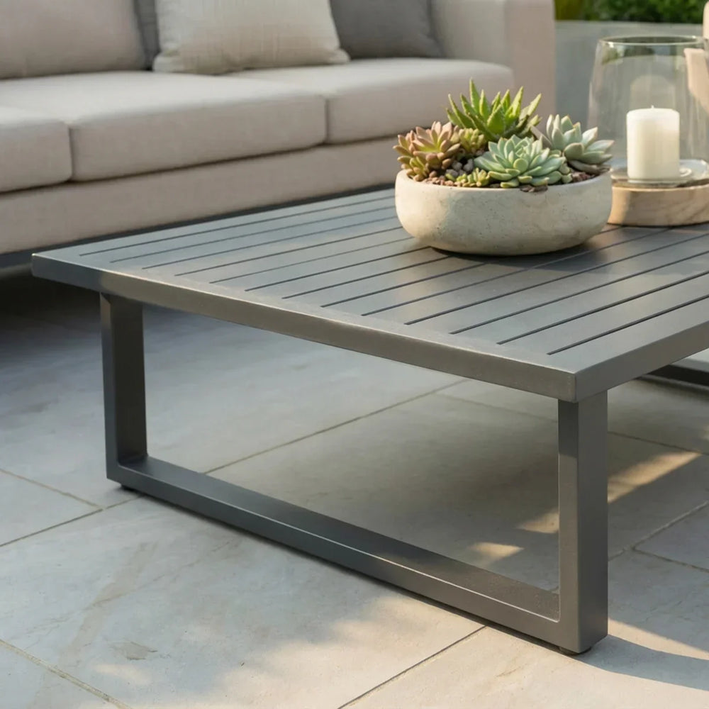 Grey metal outdoor coffee table with slatted top, decorative succulent bowl and candle
