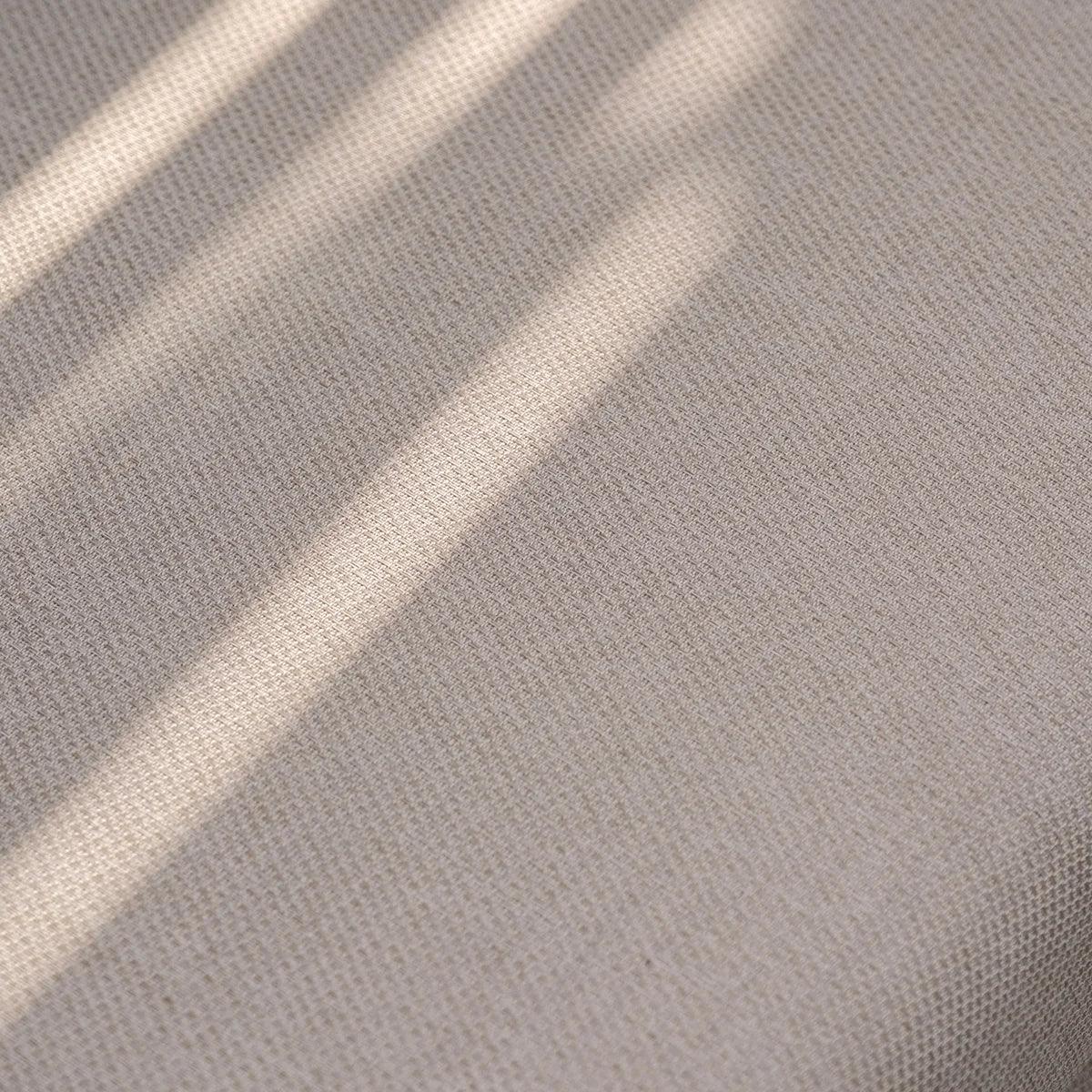 Beige sofa fabric closeup with sunlight and subtle textured weave pattern visible