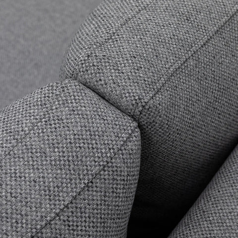 Close-up of grey fabric sofa armrest showing textured upholstery and stitching