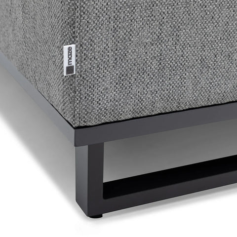 Grey fabric sofa corner with metal base and Maze label close-up
