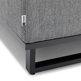 Grey fabric sofa corner with metal base and Maze label close-up