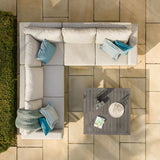 Corner outdoor sofa set with grey cushions and metal coffee table on stone patio
