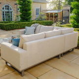 Beige outdoor corner sofa with cushions on stone patio in garden setting