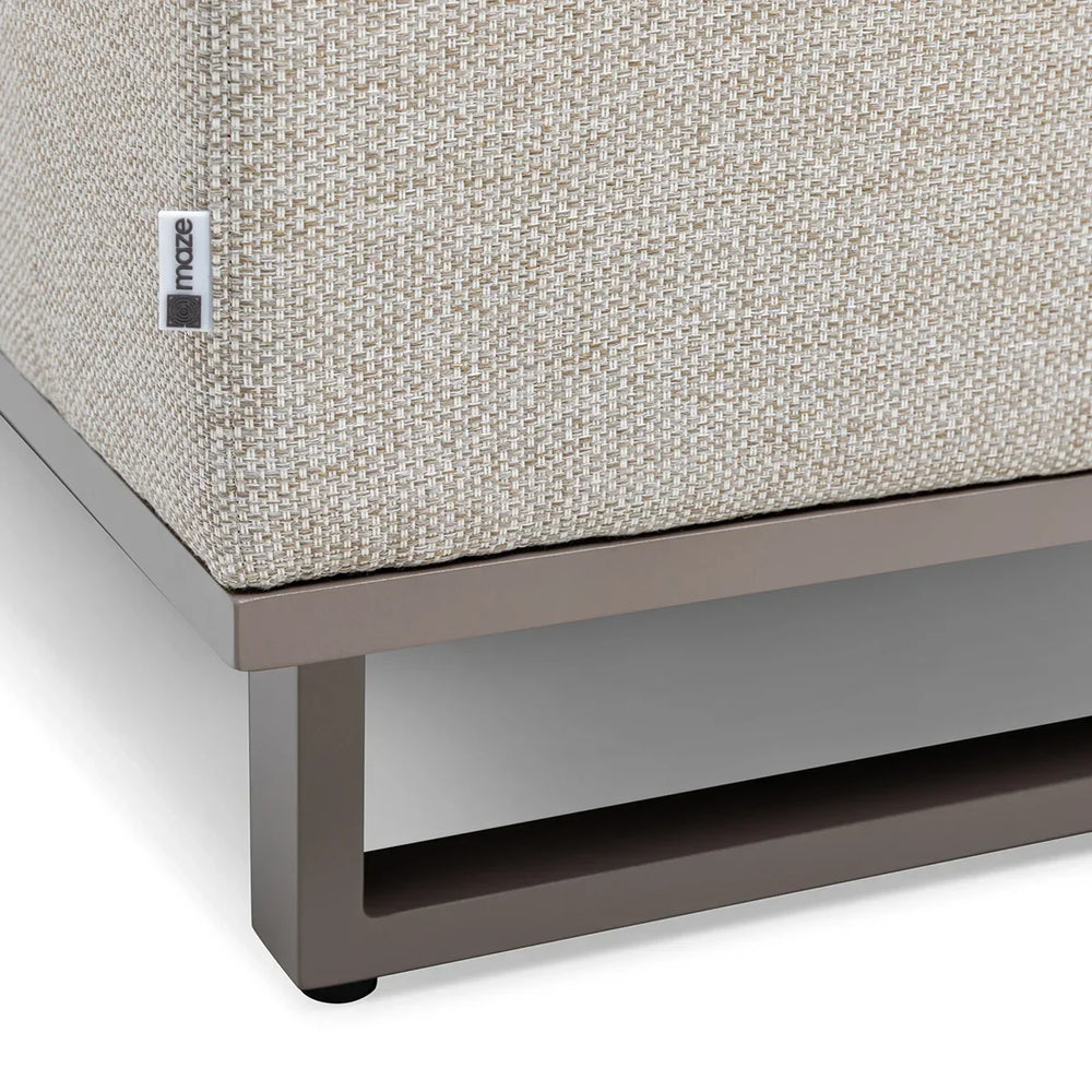 Beige woven outdoor sofa cushion on grey metal frame, corner close-up