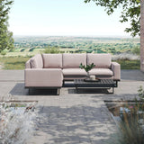 Light beige outdoor corner sofa with black coffee table on paved patio overlooking countryside