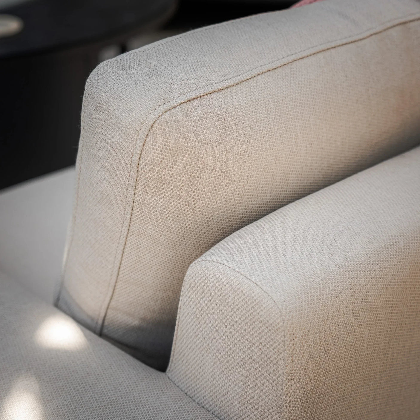 Close-up of beige fabric sofa cushions with textured upholstery