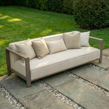 Beige outdoor garden sofa with metal frame and cushions on stone patio