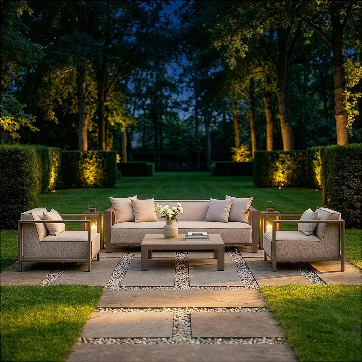 Outdoor garden furniture set with sofa, armchairs and coffee table on stone patio at dusk