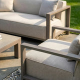 Outdoor lounge set with taupe metal frame and grey cushions on patio