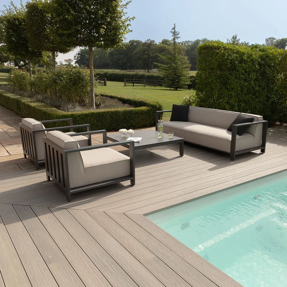 Modern outdoor sofa set with grey metal frame by pool on wooden deck in garden setting