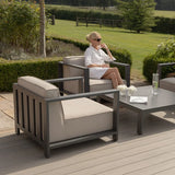 Grey outdoor lounge chair set with beige cushions and matching coffee table on patio decking