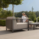 Grey metal frame outdoor armchair with beige cushions on patio beside coffee table