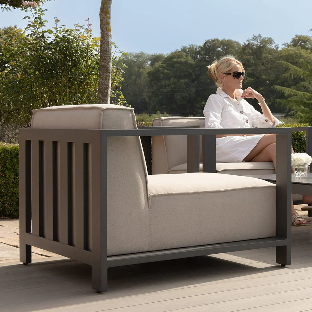 Outdoor aluminium armchair with beige cushions on patio seating area