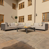 Grey outdoor corner sofa set with cushions and coffee table on patio