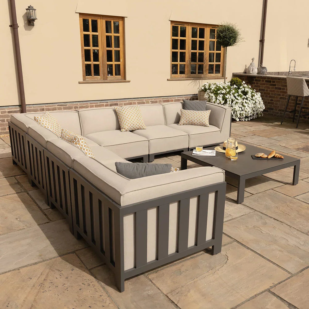 Beige outdoor corner sofa set with cushions and grey frame on patio with coffee table