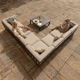 Beige outdoor corner sofa set with scatter cushions and coffee table on stone patio