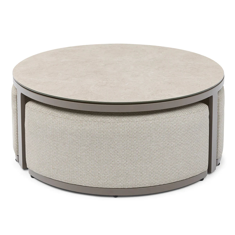 Round beige coffee table with cushioned base and smooth stone-effect top