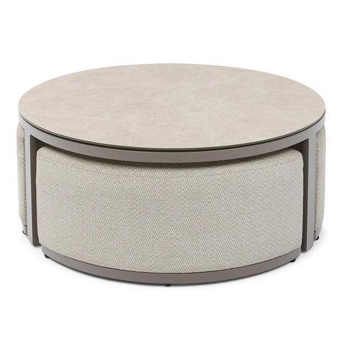 Round beige coffee table with cushioned base and smooth stone-effect top