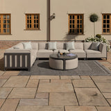 Beige outdoor corner sofa set with round coffee table and scatter cushions on a patio