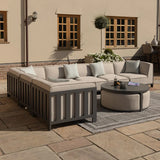Outdoor corner sofa set with grey frame and beige cushions on patio, round coffee table in front