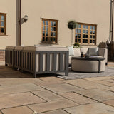 Grey outdoor sofa set with cushions and round coffee table on patio near house