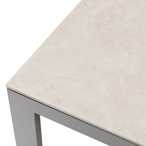 Close-up of rectangular dining table with light stone effect ceramic top and grey metal frame
