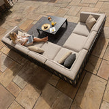 Beige outdoor corner sofa set with cushions and coffee table on a stone patio