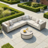 Beige outdoor corner sofa set with cushions and circular coffee table on patio