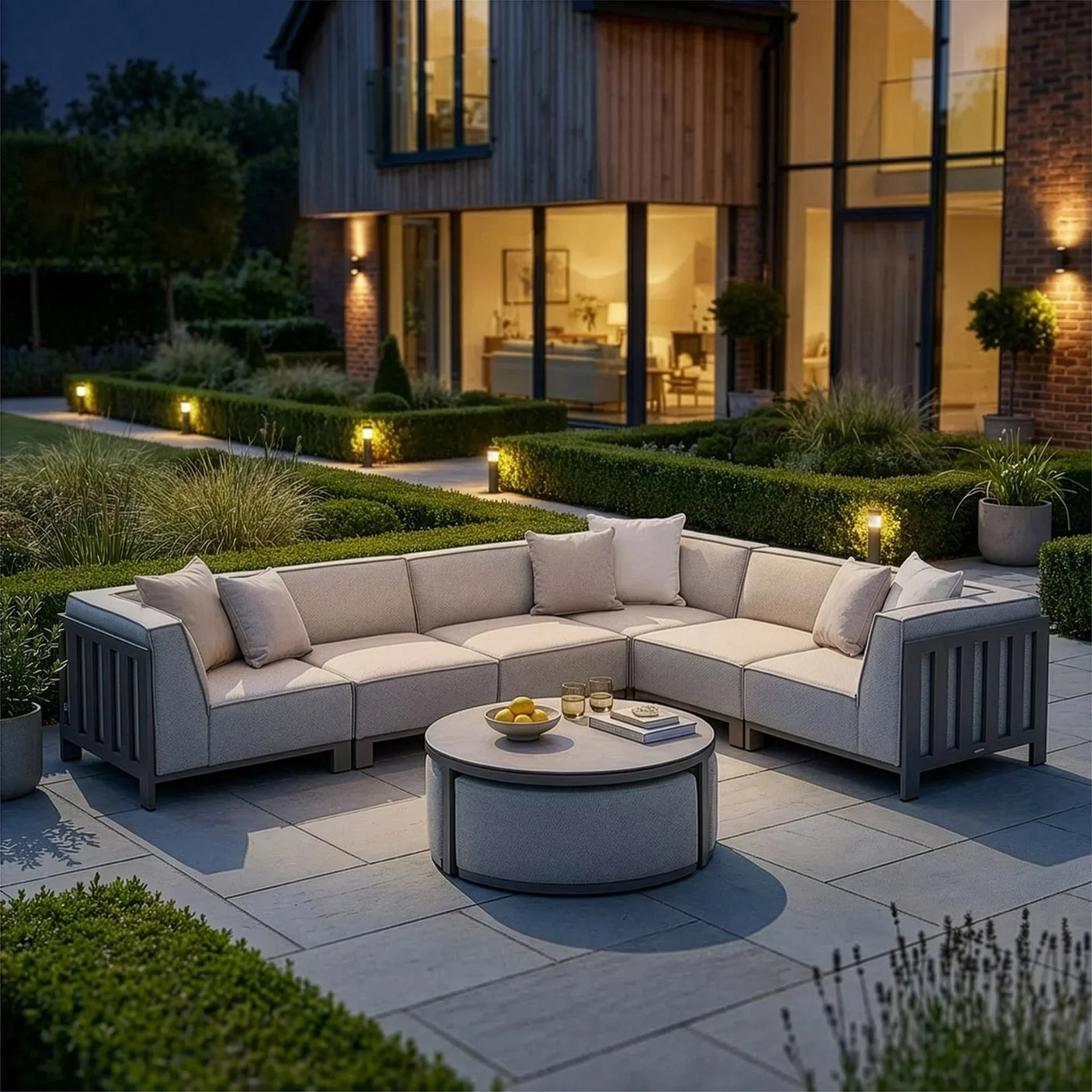 Outdoor corner sofa set with light grey cushions and round coffee table on patio