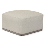 Contemporary fabric footstool with beige upholstery and grey base on white background