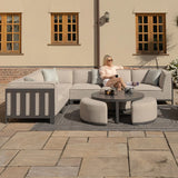 Modern outdoor corner sofa set in light grey with round coffee table on patio